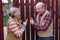 Two senior neighbors takling to each other on sunny day near fence