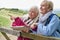 Two Senior Women Friends On Walking Holiday Resting On Gate With Map