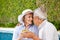 Two seniors with champagne at pool