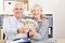 Two seniors hold up euro bills