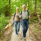 Two seniors walking with dog in forest