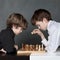 Two serious boy playing chess, studio