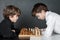 Two serious boy playing chess, studio