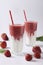 Two servings of homemade double layer smoothies with fresh strawberries, mint and yogurt in glasses on white background, Diet and