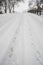 Two sets of footprints side by side on a snowy hill