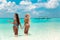 Two sexy bikini models having fun on tropical beach, exotic Maldives island. Summer vacation. Happy smiling women in fashion