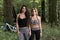 Two sexy female mountain bikers in shade of forest - summer