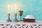 Two shabbat candlesticks with burning candles over wooden table