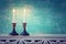 Two shabbat candlesticks with burning candles over wooden table