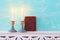 Two shabbat candlesticks with burning candles over wooden table