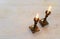 Two shabbat candlesticks with burning candles over wooden table. top view