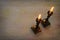 two shabbat candlesticks with burning candles over wooden table. top view. low key