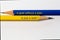 Two sharpened pencils in blue and yellow point in different directions isolated against a white background with the phrase: a goal