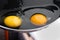Two shiny bright round yolks in raw transparent whites, uncooked small fried eggs is a simple breakfast