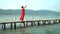 Two a shot in video. Phu Quoc Island. The woman costs on a pier with the straightened hands. The woman looks at open