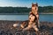 Two siberian husky dogs side by side on the shore. Portrait on the summer evening beach background.