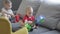 two sibling brothers toddler kids playing toys sitting grey sofa in living room