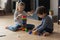 Two sibling children completing tower model form plastic building blocks