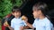 Two sibling girls having break during family road trip and eating fried chicken in trunk of car on the park. Delivery service and