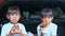 Two sibling girls having break during family road trip and eating fried chicken in trunk of car on the park. Delivery service and