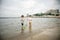 Two sibling little brother boy exploring the beach at low tide w