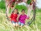 Two siblings children is swinging on a flower swing in a nature field for relaxation and childhood hapiness concept