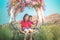 Two siblings children is swinging on a flower swing in a nature field for relaxation and childhood hapiness concept