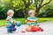 Two siblings, kid boys playing with red school bus