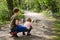 Two siblings kids, Cute little toddler girl and school boy feeding wild geese family in a forest park. Happy children