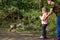 Two siblings kids, Cute little toddler girl and school boy feeding wild geese family in a forest park. Happy children