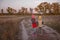 Two siblings stand near a country road and talks during beautiful autumn forest walk