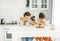 Two siblings tween boys real brothers with fun faces having breakfast on bright kitchen at home