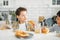 Two siblings tween boys real brothers having breakfast on bright kitchen at home