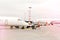 Two side profile parked airplanes with windows of wide-body airplane.