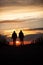 Two silhouetted seniors walking in sunset