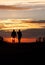 Two silhouetted seniors walking in sunset