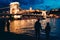 Two silhouettes of the loving couple holding hands on the riverbank of Danube and enjoying the beautiful landscape view