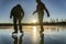 Two silhouettes: teenage boys are ice skating on the crystal clear frozen lake in Northern Sweden - ice like big mirror. One