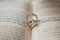 Two silver engagement wedding rings lie on an open Torah book