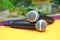 Two silver microphones isolated over yellow background . Two wireless microphones on the conference table