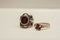 Two silver rings with natural red garnet stone on a white background.