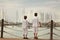 Two similar brother standing on waterfront,
