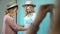 Two similar girls in hats and dresses are photographed in a studio