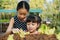 Two sister planting seedling in farm