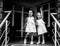 Two sisters baby girls in the same dresses, holding hands. Black and white photo