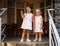 Two sisters baby girls in the same dresses, holding hands, happy family