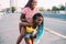 Two sisters black women outdoor having fun hugging riding piggyback