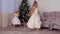 Two sisters children girls beautiful white dresses dancing near Christmas tree.