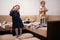 Two sisters are choosing clothes from the wardrobe at home on the sofa. Girl shows a gesture with two fingers