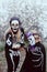 Two sisters dressed up as skeleton and witch having fun at Halloween party and trick-or-treating outdoors